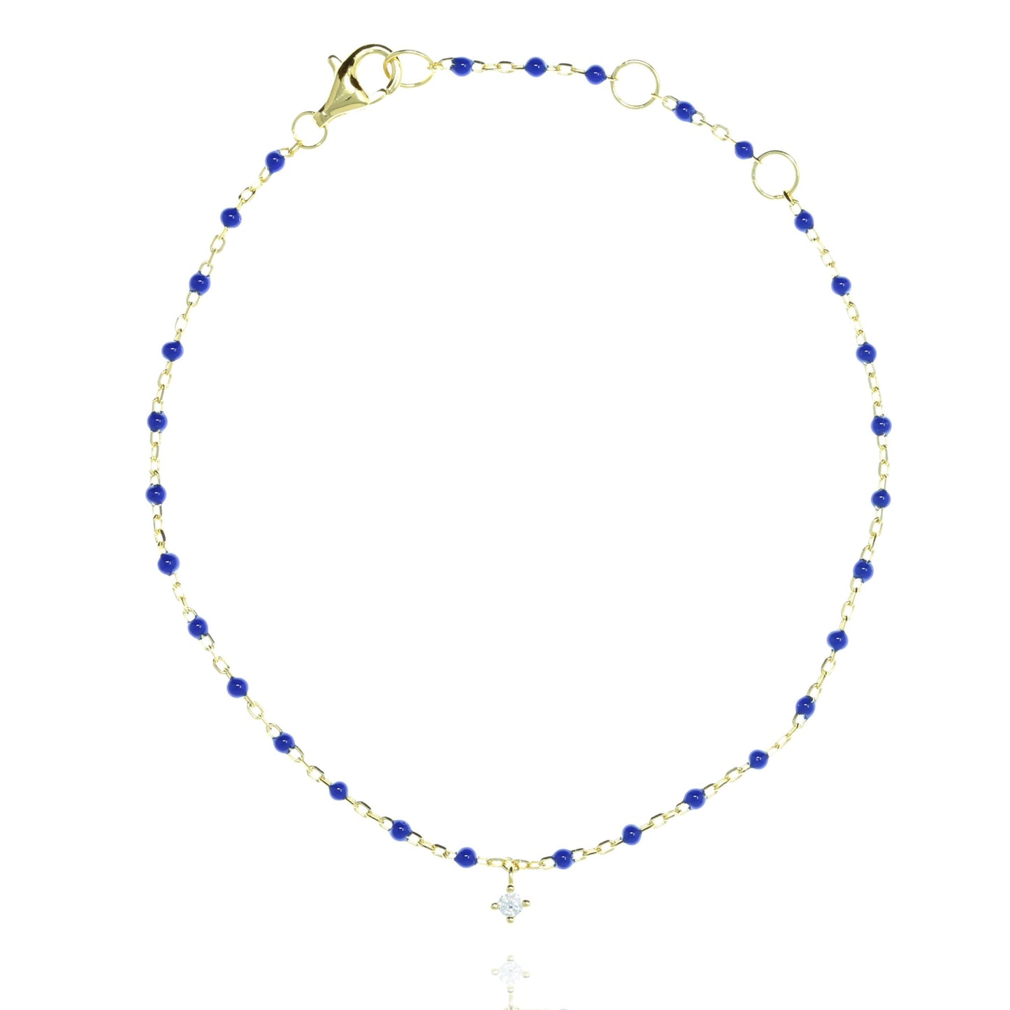 Blue bead and gold chain bracelet with hanging CZ.